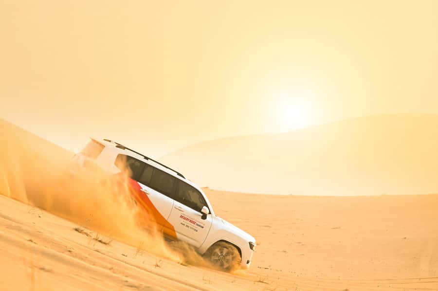 From Abu Dhabi: Dune Bashing Desert Safari - Sandboarding adds a gentler kind of speed